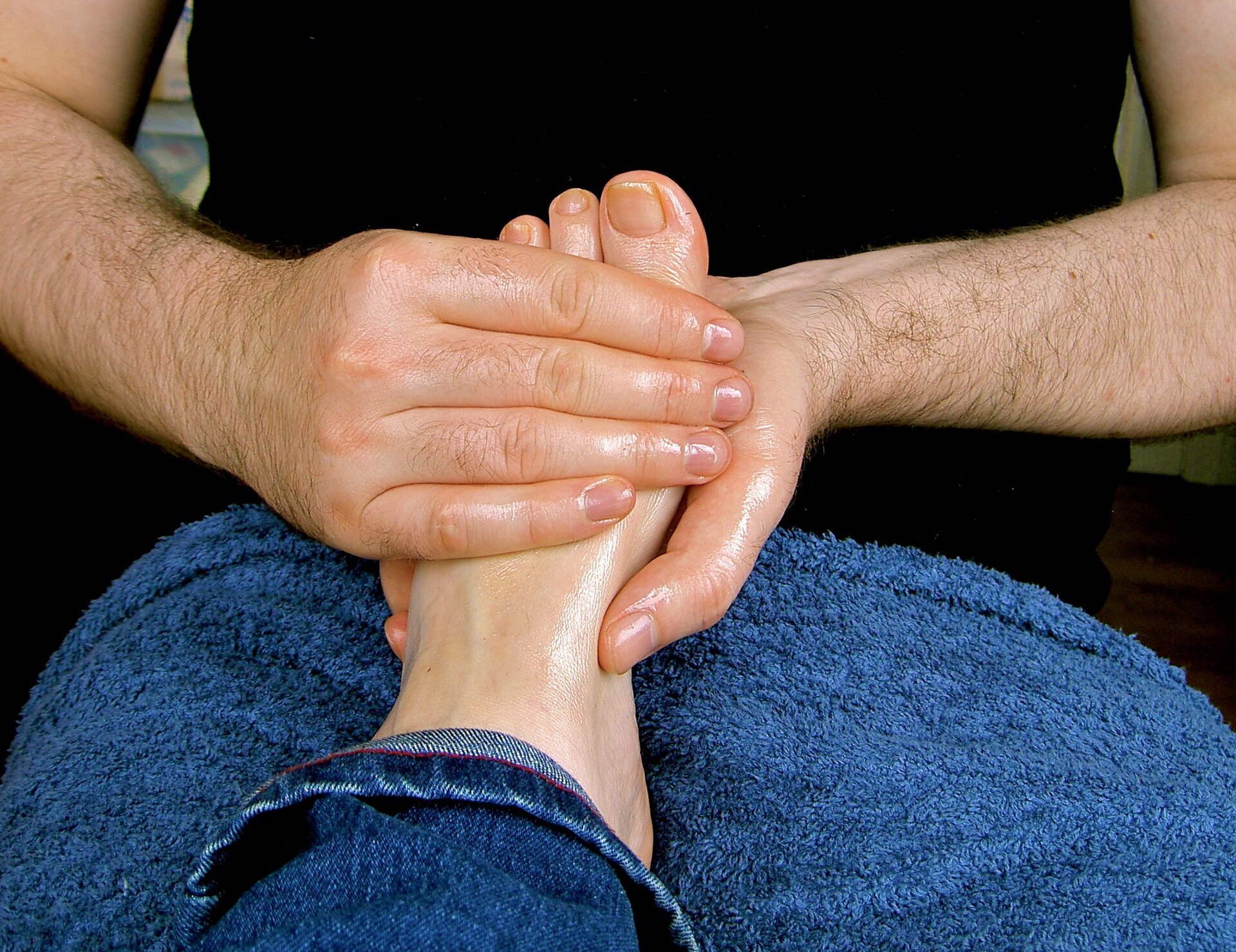 Close view of a therapist providing an oil foot massage